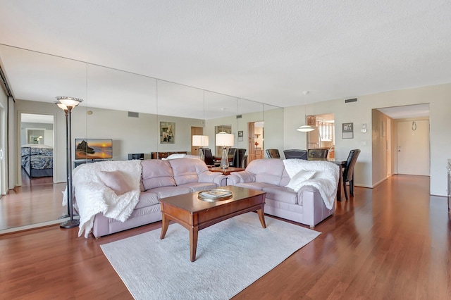 living room with dark hardwood / wood-style flooring and a textured ceiling