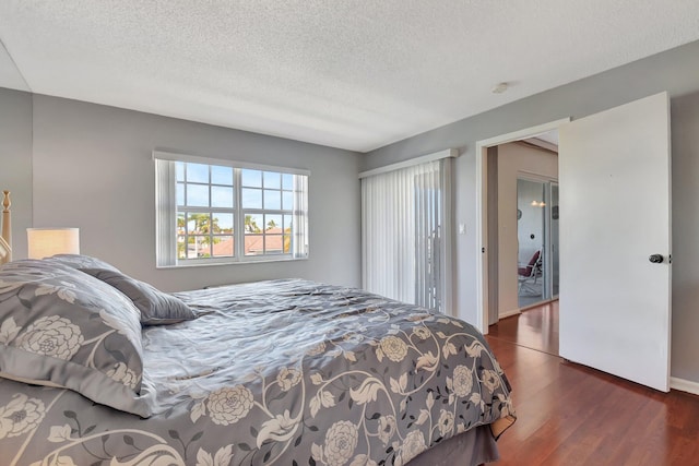 bedroom featuring dark wood-type flooring and a textured ceiling