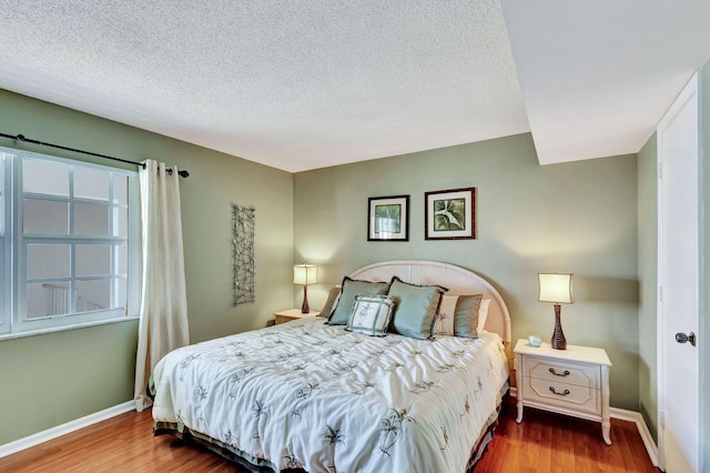 bedroom with wood-type flooring and a textured ceiling