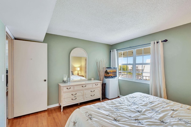 bedroom featuring light hardwood / wood-style floors and a textured ceiling