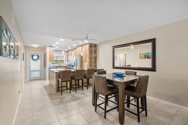 tiled dining room featuring a textured ceiling and ceiling fan