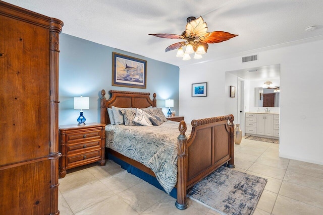 tiled bedroom with connected bathroom, ceiling fan, sink, and a textured ceiling