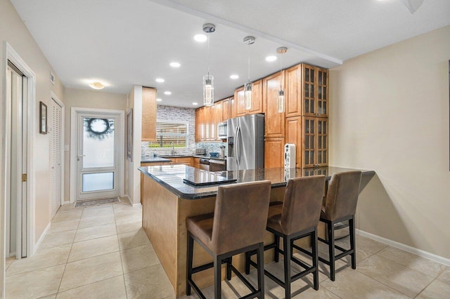 kitchen featuring kitchen peninsula, stainless steel refrigerator with ice dispenser, decorative backsplash, light tile patterned floors, and a breakfast bar area