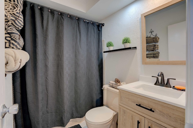 bathroom featuring walk in shower, vanity, and toilet