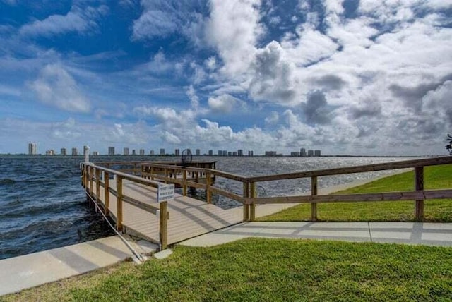 dock area featuring a water view and a lawn