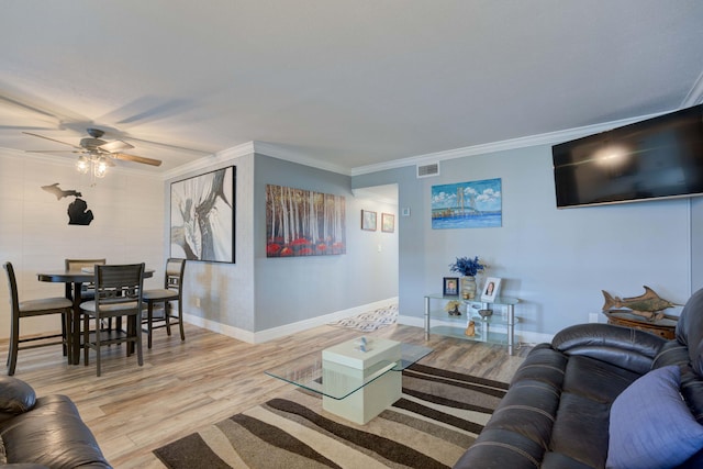 living room with crown molding, light hardwood / wood-style flooring, and ceiling fan