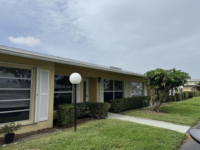 2541 Red Hibiscus Blvd Unit 31-B, Delray Beach, FL 33445 - view of front of home featuring a front yard and stucco siding