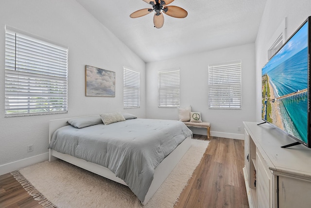 bedroom with wood-type flooring, ceiling fan, and vaulted ceiling