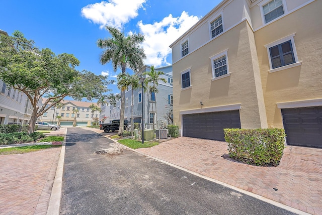 view of property featuring a garage and central AC