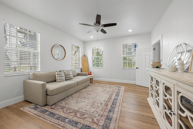 living room with ceiling fan and light wood-type flooring