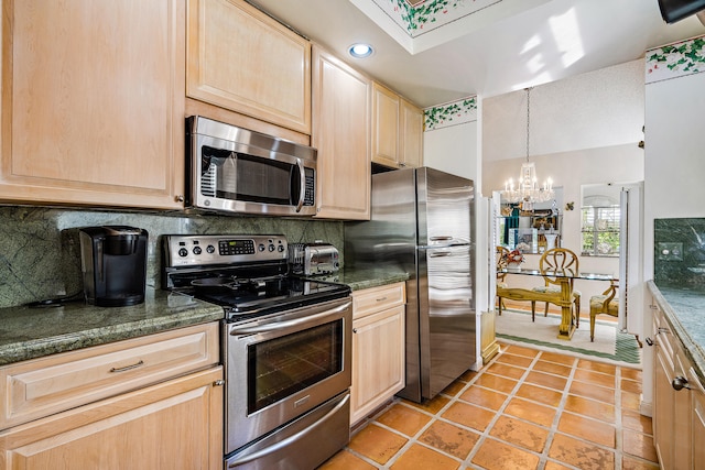 kitchen featuring appliances with stainless steel finishes, a chandelier, backsplash, and light brown cabinets