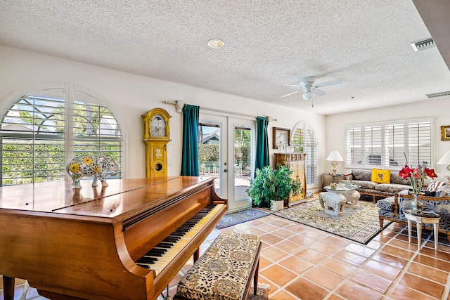 misc room featuring french doors, tile flooring, ceiling fan, and a textured ceiling