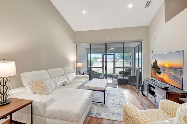 living room with lofted ceiling and light wood-type flooring