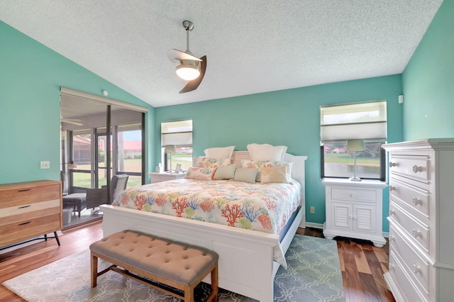 bedroom featuring access to exterior, a textured ceiling, vaulted ceiling, ceiling fan, and dark wood-type flooring