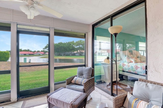 sunroom / solarium featuring plenty of natural light, ceiling fan, and a water view