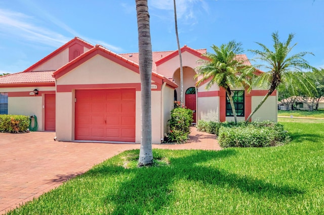 mediterranean / spanish-style house with a front yard and a garage