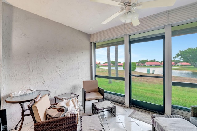 sunroom featuring a water view and ceiling fan