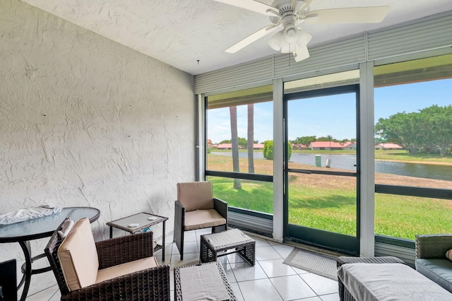 sunroom with a water view, plenty of natural light, and ceiling fan