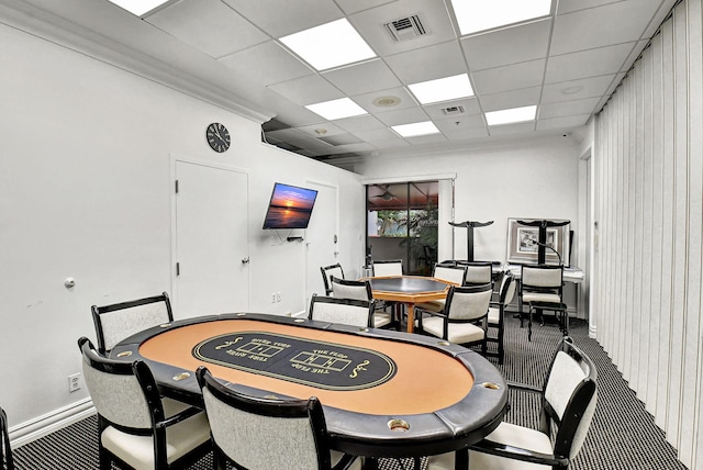 carpeted dining room with a drop ceiling and wood walls