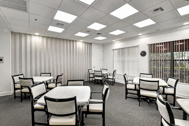 carpeted dining room featuring a drop ceiling