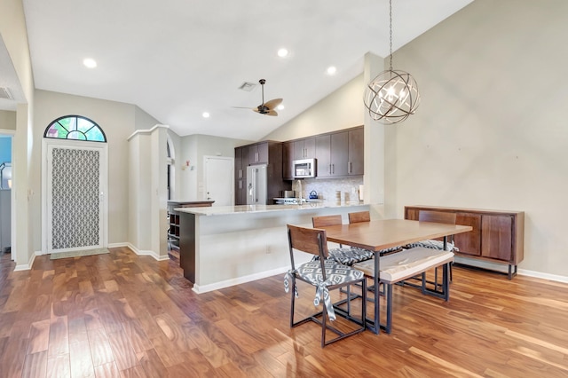 kitchen featuring ceiling fan, light wood-type flooring, white fridge with ice dispenser, dark brown cabinets, and kitchen peninsula