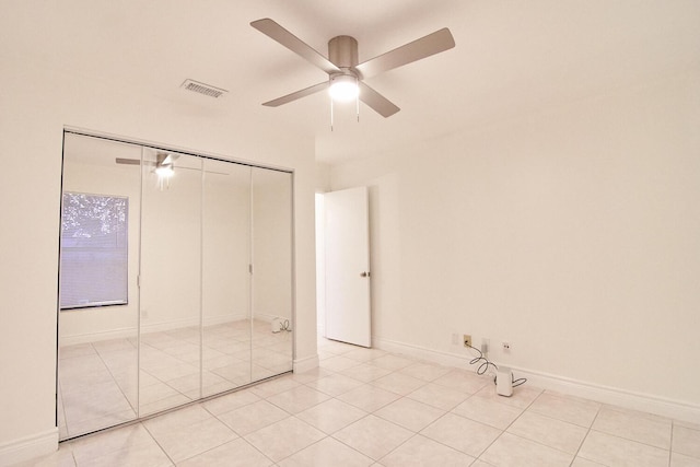 unfurnished bedroom with ceiling fan, light tile patterned floors, and a closet