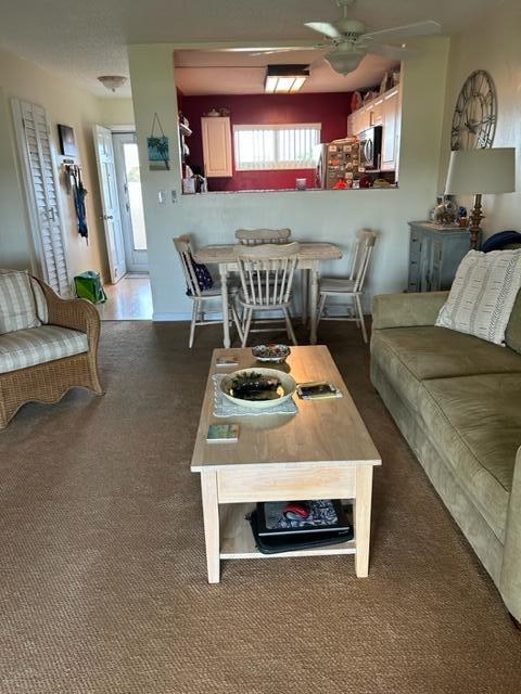 carpeted living room with ceiling fan