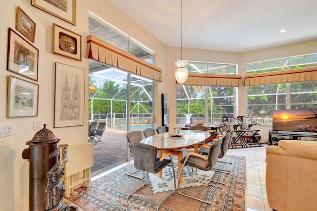 dining area with a high ceiling, tile patterned floors, and plenty of natural light