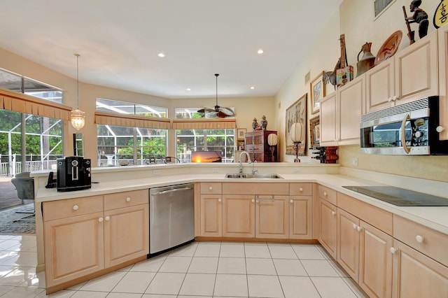 kitchen featuring pendant lighting, stainless steel appliances, sink, and kitchen peninsula