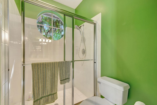 bathroom with toilet and an enclosed shower