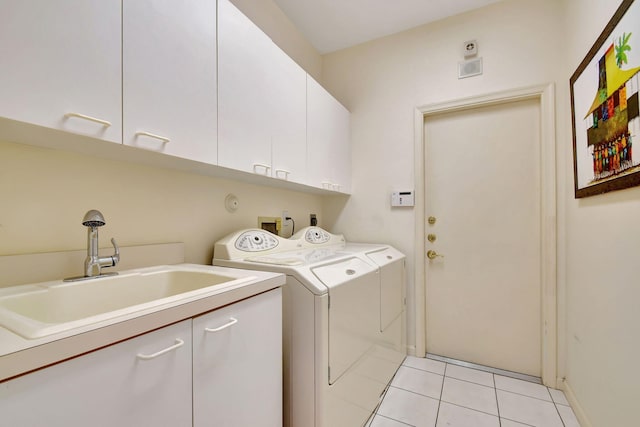 laundry room featuring sink, light tile patterned flooring, cabinets, and washing machine and clothes dryer