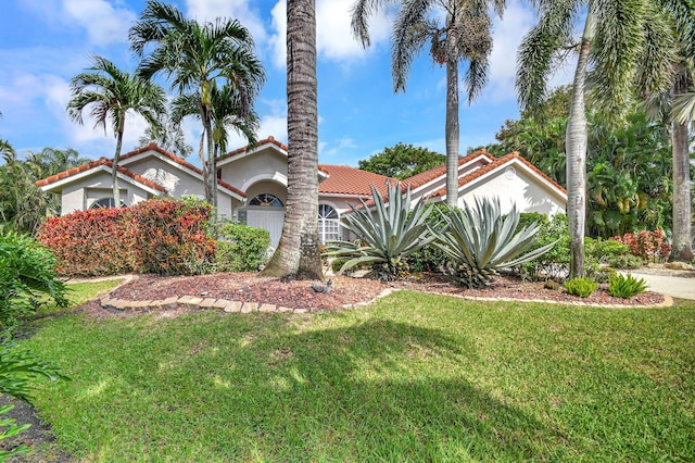 mediterranean / spanish home with a front lawn