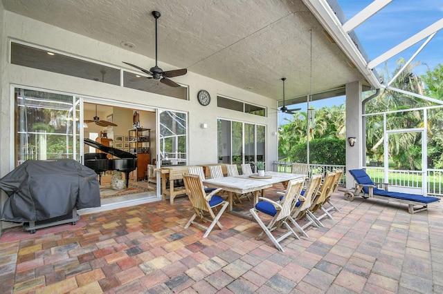 view of patio featuring a lanai, grilling area, and ceiling fan