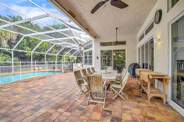 view of patio / terrace featuring a fenced in pool, glass enclosure, and ceiling fan