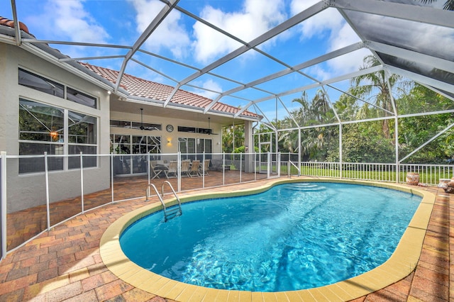 view of swimming pool with a patio, ceiling fan, and glass enclosure