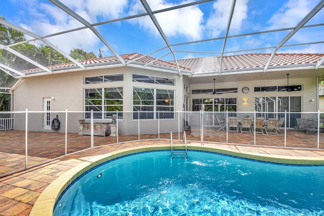 view of swimming pool featuring ceiling fan, a patio area, and a lanai