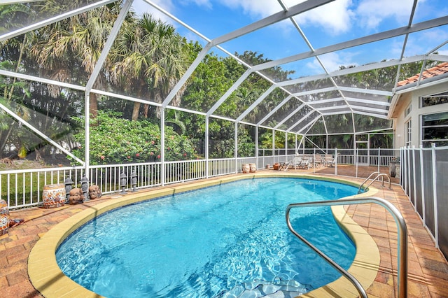 view of swimming pool with a patio area and a lanai