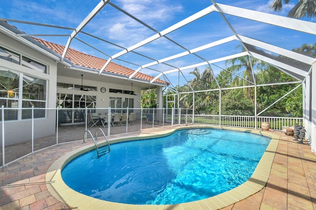 view of pool featuring ceiling fan, a patio, and a lanai