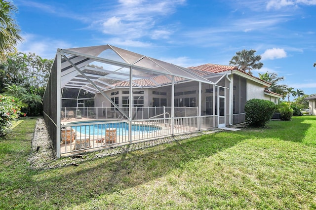 rear view of property featuring a patio area, a lanai, and a lawn