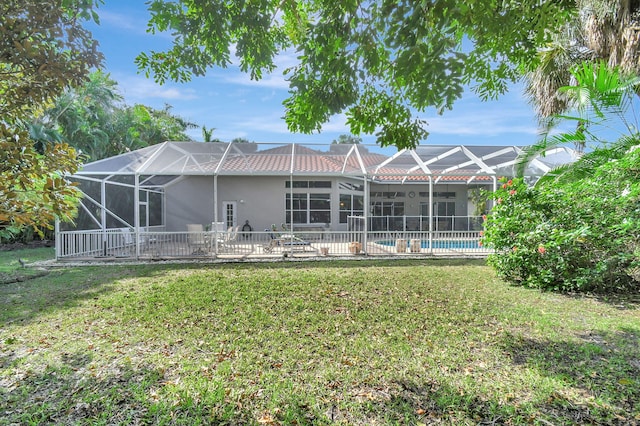 rear view of property featuring a patio, a lanai, and a yard