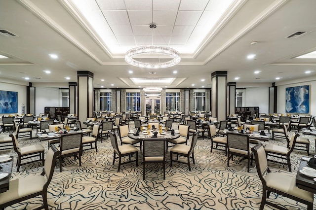 dining space with light carpet, an inviting chandelier, crown molding, and a raised ceiling