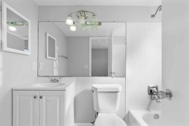 full bathroom with tiled shower / bath, a chandelier, toilet, and large vanity