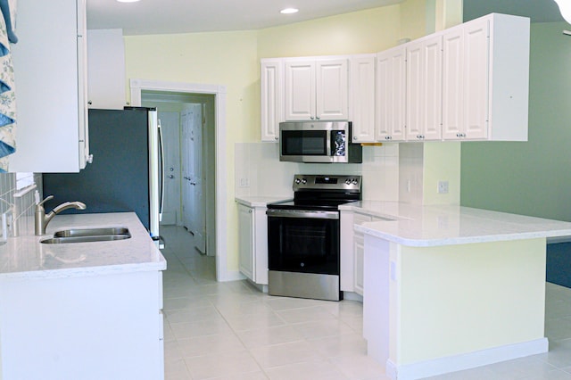 kitchen with white cabinetry, light tile patterned flooring, stainless steel appliances, sink, and kitchen peninsula