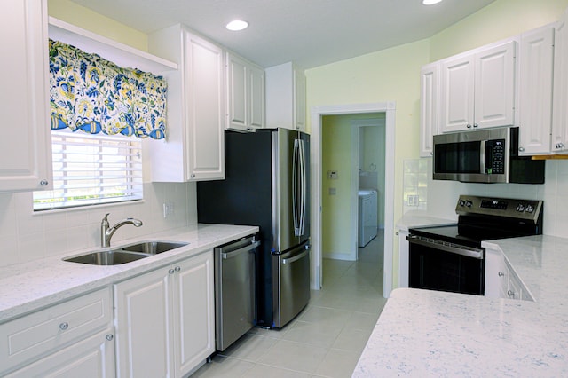 kitchen featuring decorative backsplash, white cabinets, light stone counters, appliances with stainless steel finishes, and light tile patterned floors