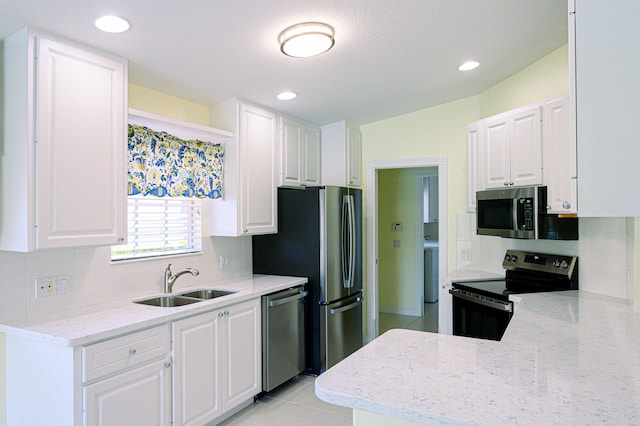 kitchen with white cabinetry, light tile patterned floors, appliances with stainless steel finishes, decorative backsplash, and sink