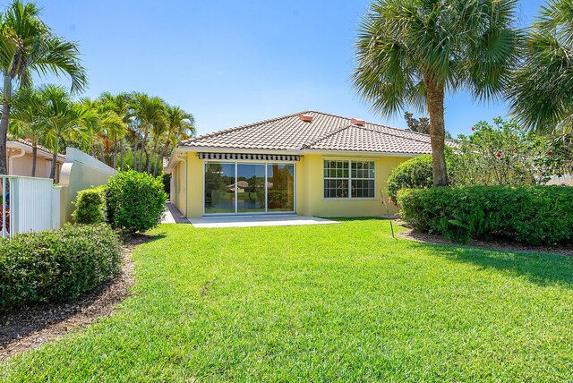 rear view of property with a patio and a yard