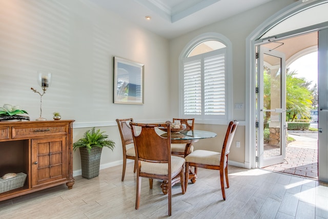 dining space with ornamental molding, light hardwood / wood-style flooring, and a healthy amount of sunlight