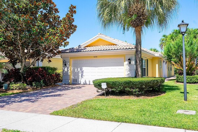 view of front of home with a garage and a front lawn