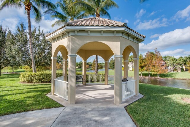 view of community with a yard, a gazebo, a water view, and a patio area