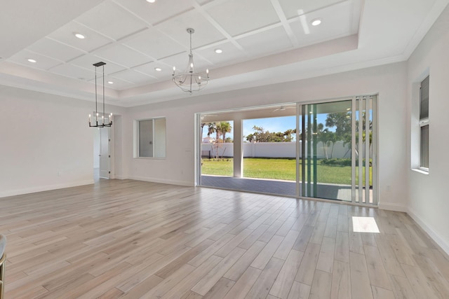 unfurnished living room with coffered ceiling, a notable chandelier, light wood-style flooring, and baseboards